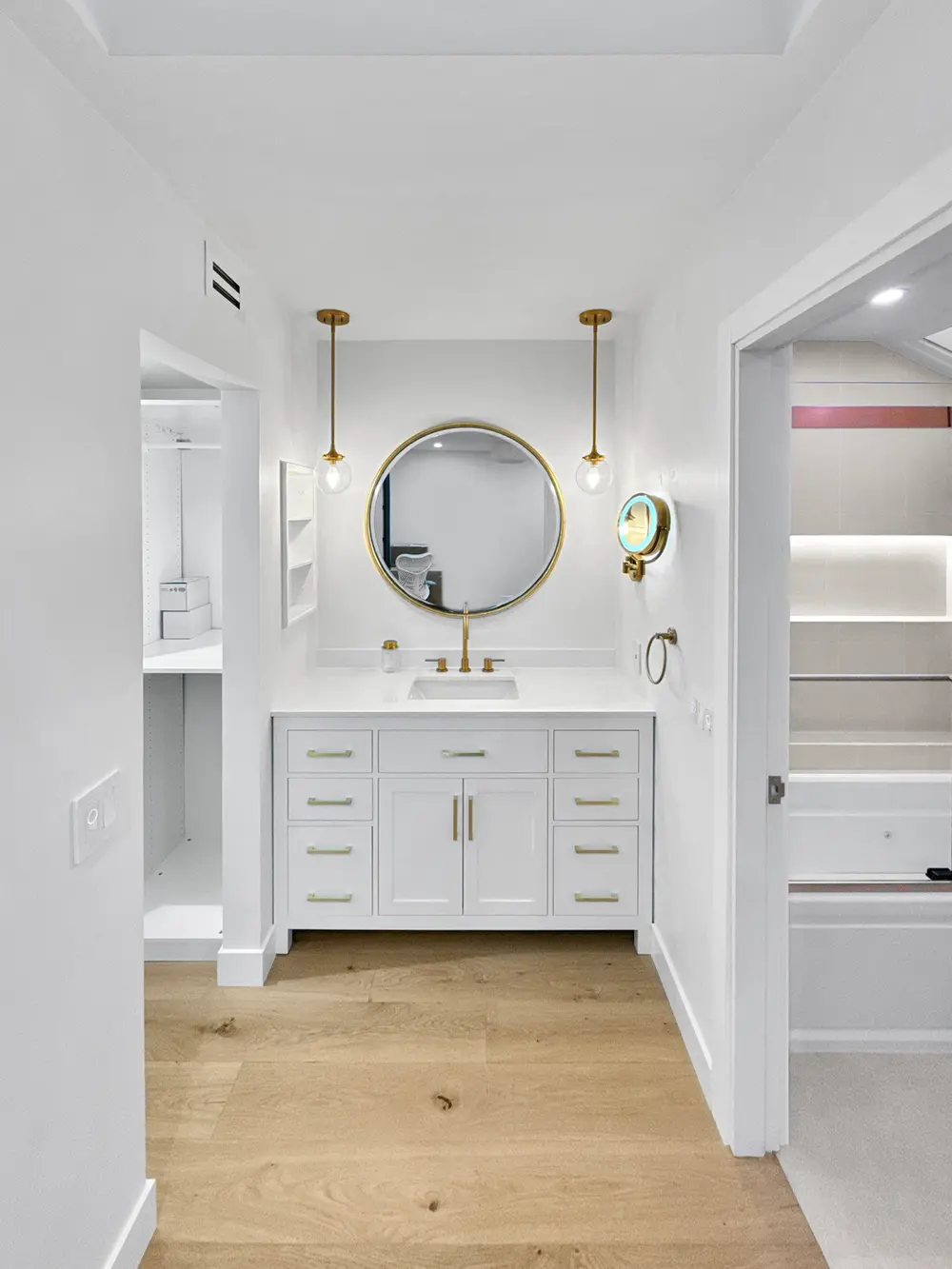Interior remodel by Avanti Construction — bright bathroom with custom vanity and brass fixtures